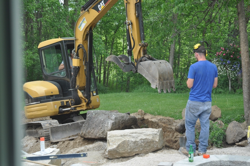 Excavator digging in backyard garden
